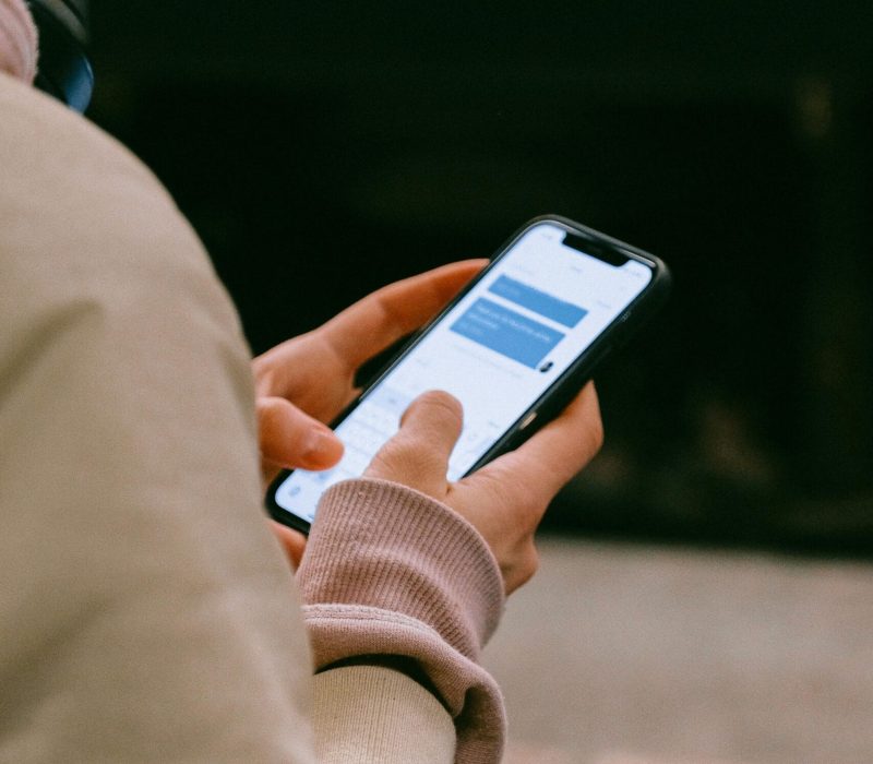 A person using a smartphone for texting, focusing on their hands and device screen.
